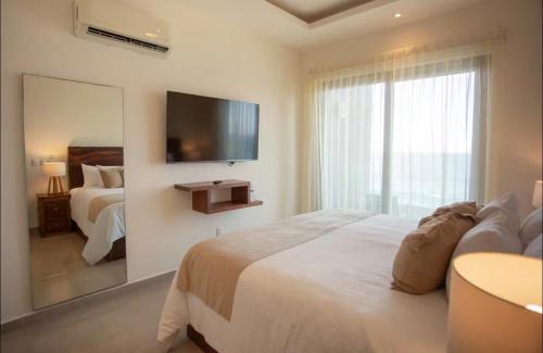 a bedroom with a large bed and a large window at Apartamento en Punta Mita in Higuera Blanca