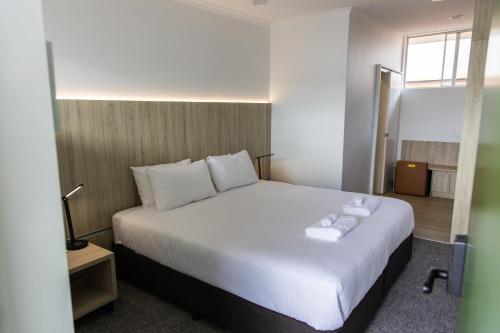 a bedroom with a large white bed with towels on it at The Royal Casino in Casino