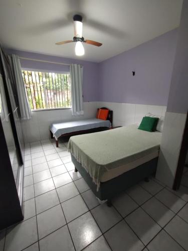 a bedroom with two beds and a ceiling fan at Chácara Paraíso do Mar - Araçagi in São José de Ribamar