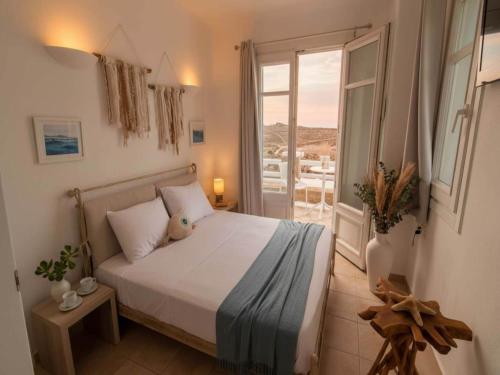 a bedroom with a bed and a door to a patio at Mykonos Villa for 8 with Pool in Mikonos