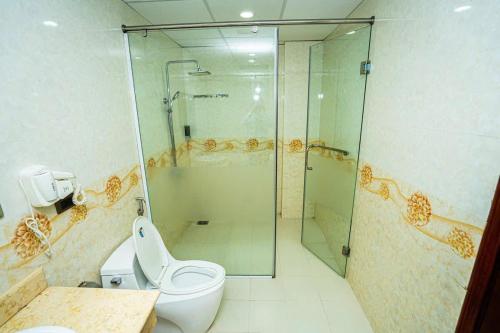 a bathroom with a glass shower and a toilet at Ks sơn trang 1 in Sầm Sơn