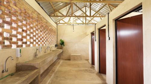 a bathroom with a row of sinks and a brick wall at Suka Camping - Bentong in Bentong