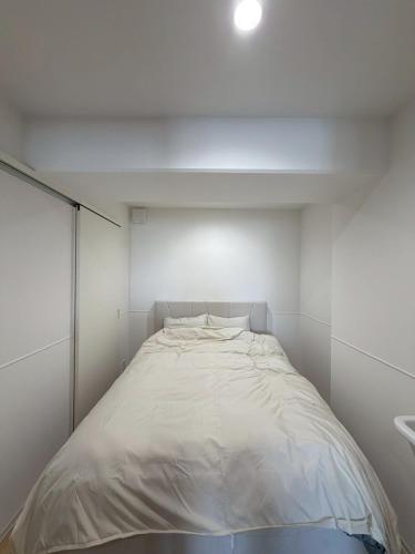 a small white room with a bed in it at Bliss長浜 in Oita