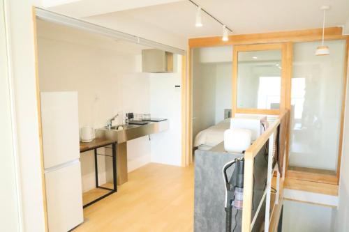 a bedroom with a bed and a sink in a room at Bliss長浜 in Oita
