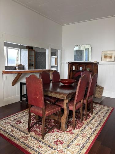 a dining room with a wooden table and chairs at Timeless Villa on Parore in Dargaville