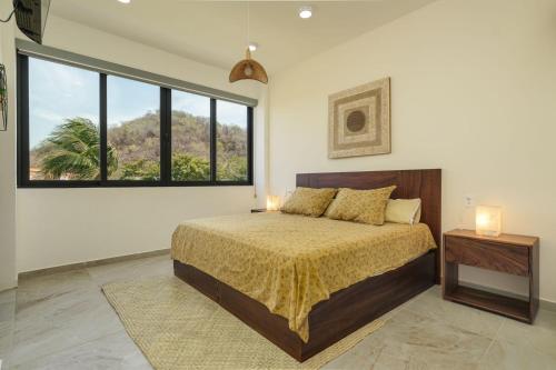 a bedroom with a bed and a large window at Nabani Condominios T2 in Santa Cruz Huatulco
