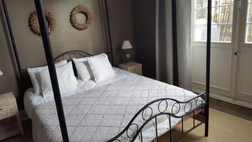 a bedroom with a bed with white sheets and pillows at Villa Grand Maur in Spa