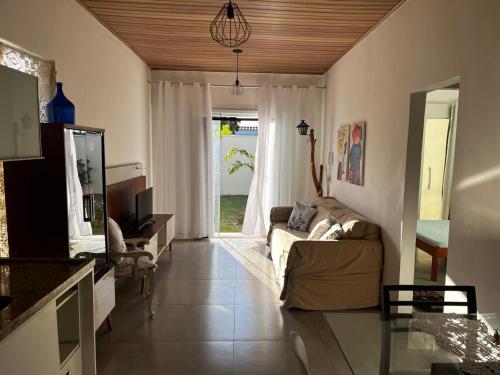 a living room with a couch and a window at Recanto Mariel - 800m praia 2 quartos churrasqueira chuveirão rede Itaipuaçu in Maricá