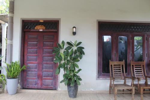 a house with a red door and a potted plant at surfing lion villa kudawella in Mawella