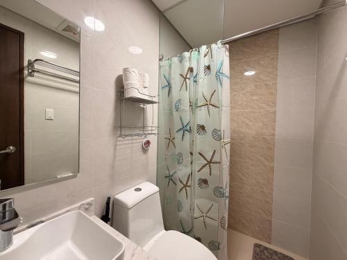 a bathroom with a toilet and a shower curtain at Serenity Ocean Garden Boracay in Boracay