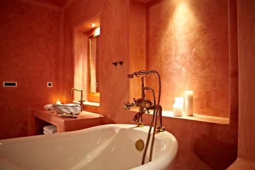 a bathroom with a white tub in a room at Voreina Gallery Suites in Pirgos