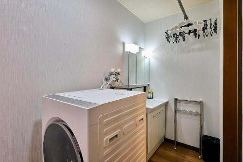 a laundry room with a washer and a sink at Furano Noie in Furano