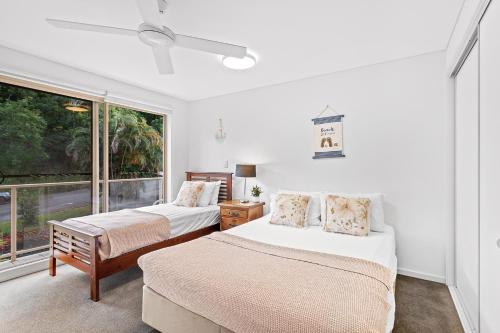 two beds in a room with a window at The Crabpot in Airlie Beach
