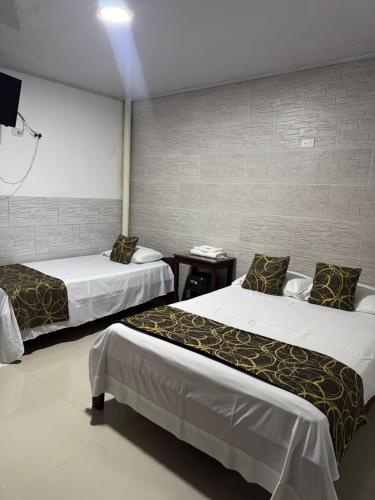 a hotel room with two beds and a tv at Hotel Beraka in Fortul