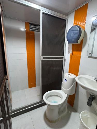a bathroom with a shower and a toilet and a sink at Hotel Beraka in Fortul