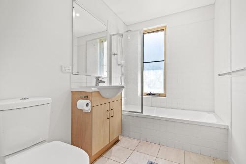 a bathroom with a sink and a toilet and a tub at The Crabpot in Airlie Beach
