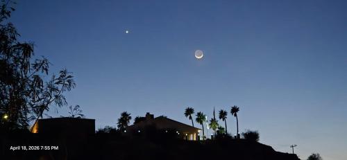 a moon in the sky over a house with palm trees at 4 River Lake Sea in Parker