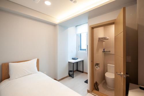 a bedroom with a bed and a bathroom with a toilet at K-Grand Hostel Sinchon in Seoul