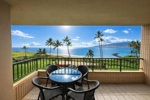a balcony with a table and chairs and a view of the ocean at Oceanfront Artist Condo Panoramic Maui Sunsets in Kihei