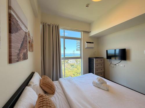 a bedroom with a bed and a large window at Serenity Ocean Garden Boracay in Boracay