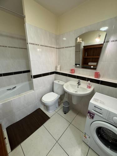 a bathroom with a toilet and a sink and a washing machine at Prana Lodge Saint Gilles les Bains 800 m de la plage in Saint-Gilles-les-Bains