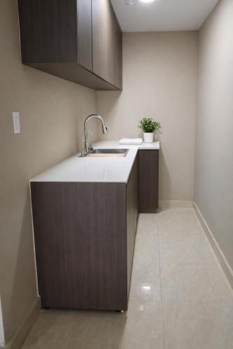 a kitchen with a sink and wooden cabinets at Gorgona Beach House in Nueva Gorgona