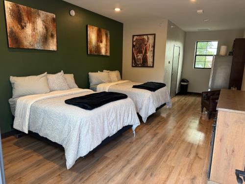two beds in a room with green walls and wooden floors at Airstay LLC in Clark