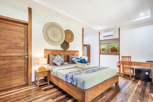 a bedroom with a bed and a door and a television at Orora Bungalows Batu Bolong Canggu in Canggu