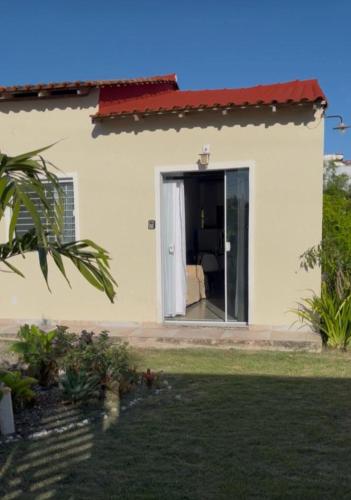 a house with a door open to a living room at Recanto Mariel - 800m praia 2 quartos churrasqueira chuveirão rede Itaipuaçu in Maricá