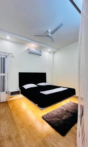 a bedroom with a black bed and a ceiling at Satkarma in Rishīkesh