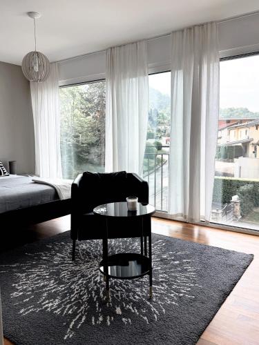 a living room with a chair and a table and a bed at Ailiv Room - Lovely Room in Capriasca in Arni Alp