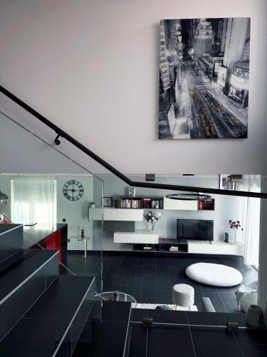 a black and white living room with a clock on the wall at Ailiv Room - Lovely Room in Capriasca in Arni Alp