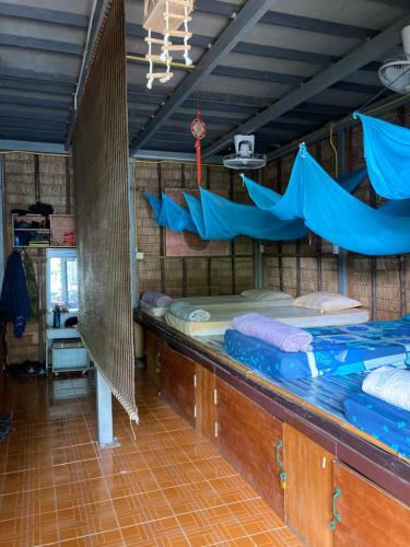 a room with two beds and nets in it at New Phiman Riverview Guesthouse in Bangkok