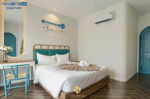 a bedroom with a bed and a desk and a chair at Santorini Homestay Phan Thiet in Tiến Thành