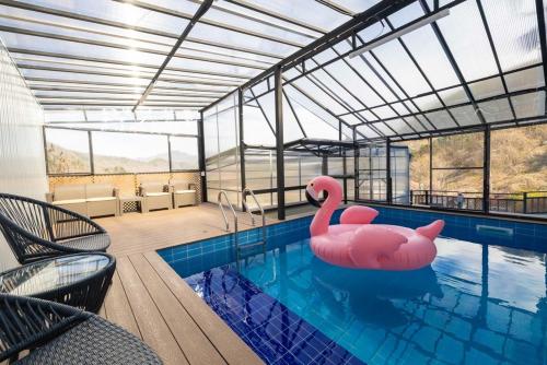 a swimming pool with a pink flamingo in the water at Gapyeong T Pension in Gapyeong