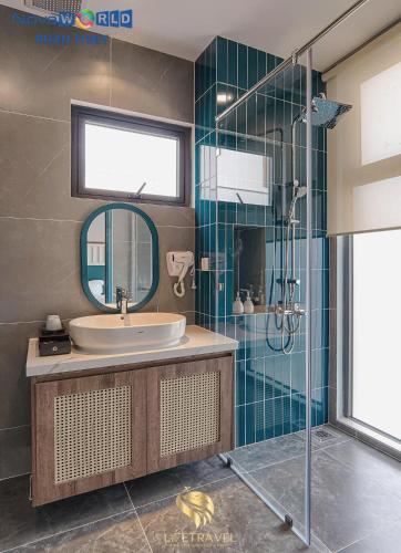 a bathroom with a sink and a shower at Santorini Homestay Phan Thiet in Tiến Thành