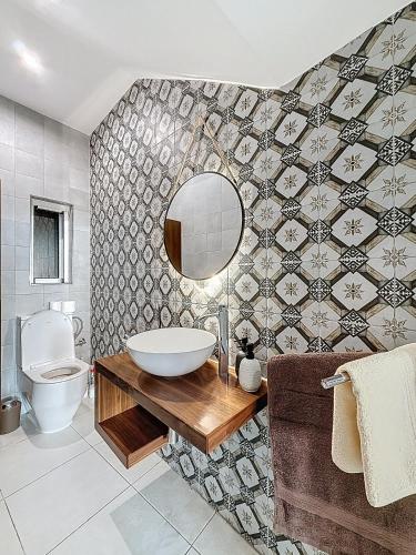 a bathroom with a sink and a toilet and a mirror at Modern Duplex Apartment with Private Pool & AC Central Malta in Balzan