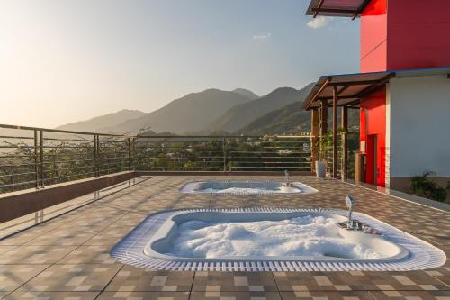 a hot tub on a balcony with mountains in the background at Perfectstayz Premium Aurevva, Rajpur road in Rājpur