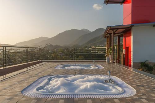 a jacuzzi tub on a balcony with mountains at Perfectstayz Premium Dehradun at Rajpur road in Dehradun