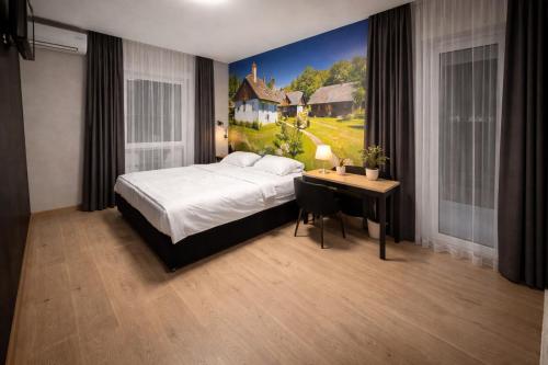 a bedroom with a bed and a desk with a painting at Gec in Zaprešić