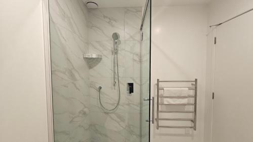a bathroom with a shower with a glass door at 20 Te Kanawa Haven in Auckland