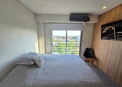 a bedroom with a large bed and a window at Duplex Premium Ciudad Jardín in El Palomar