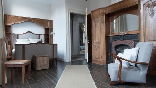 a living room with a fireplace and a chair at Villa Grand Maur in Spa