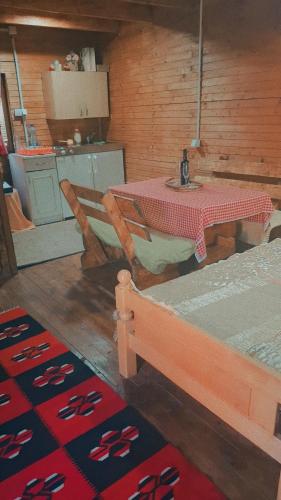 a table and chairs in a room with a table and a kitchen at Vikendica Dani in Ljubovija