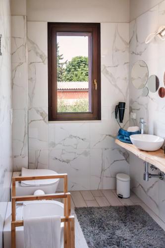 a bathroom with a toilet and a window at B&B Tra mare e montagna - sauna e piscina in San Giorgio di Pesaro