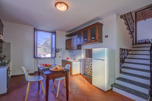 a kitchen with a table and a refrigerator and a staircase at Casa al Castello in Leggiuno with Garden - Happy Rentals in Leggiuno