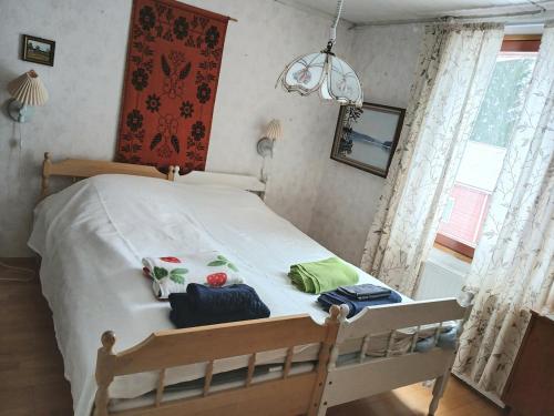 a bedroom with a bed with white sheets and a window at Villa Sukuviiri in Vimpeli