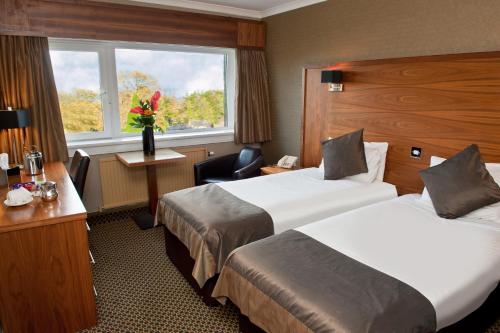 um quarto de hotel com duas camas e uma janela em Park Hotel em Falkirk