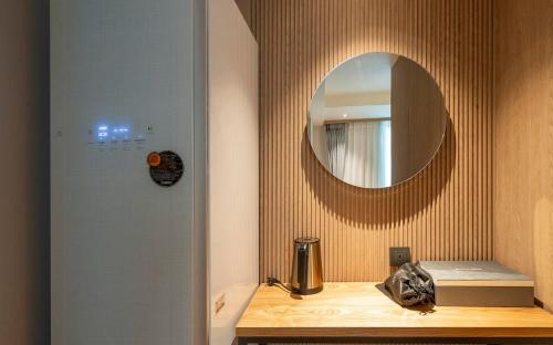 a bathroom with a mirror on the wall and a sink at Adena Hotel in Busan
