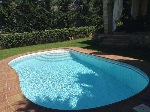 a swimming pool in a yard at Rock House's Villa Melody in Plataniás